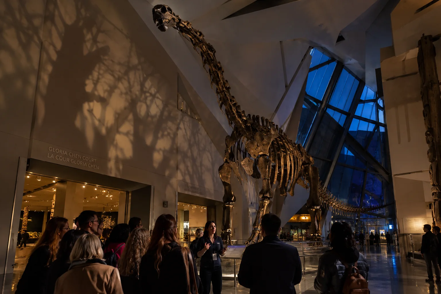 Visitors gather beneath the Futalognkosaurus skeleton in Gloria Chen Court at the ROM