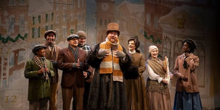 The Shaw Festival ensemble in period costumes onstage beneath warm lighting.